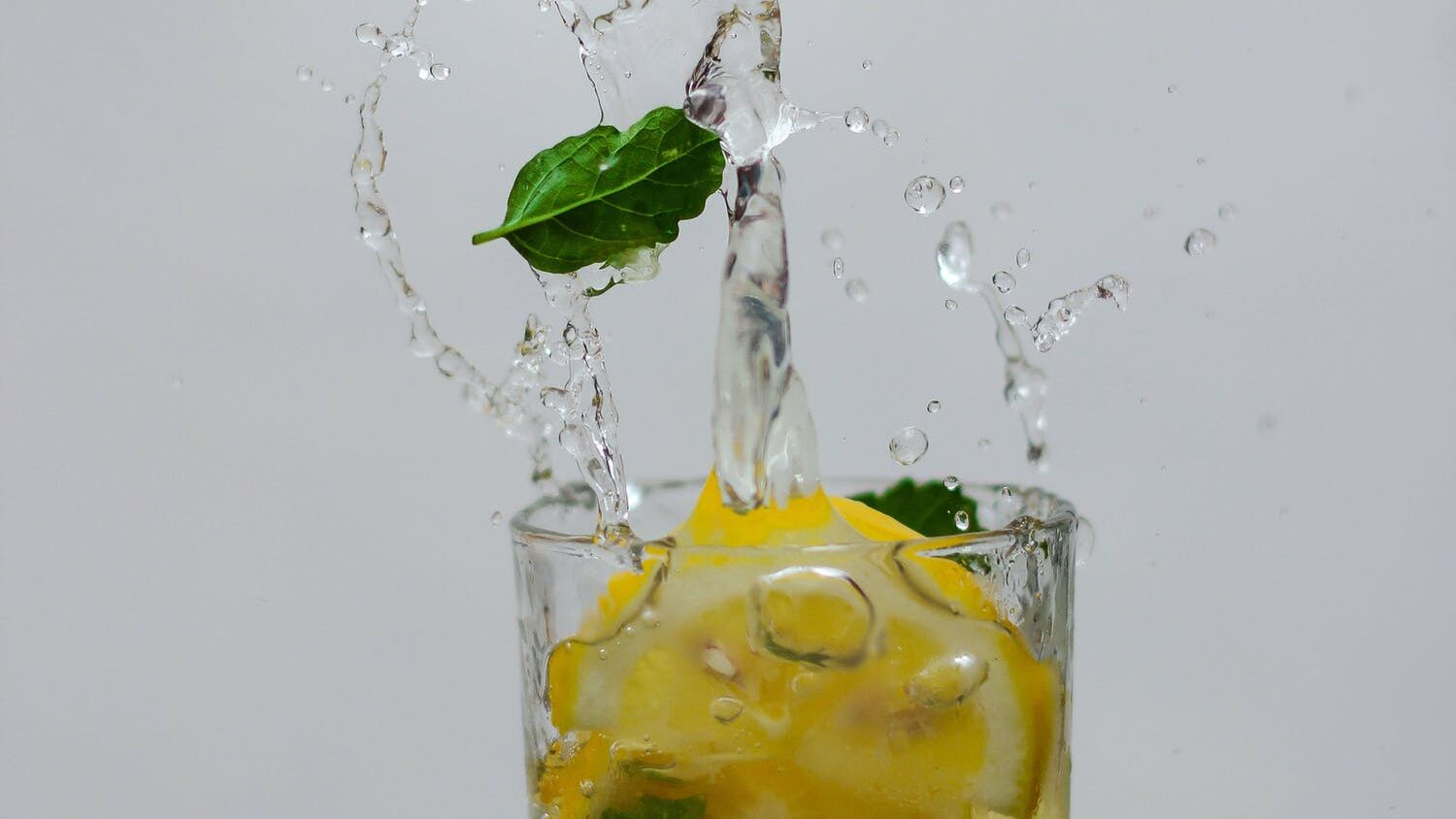 Glass of lemon water prepared by adding slices of lemon into plain water.